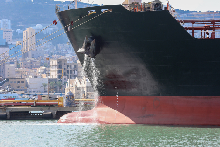 Large anchored cargo ship discharging ballast water